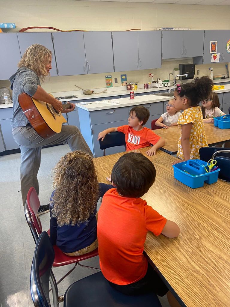 Art teacher Ms. Anderson plays the guitar for Jessica Vara's Kindergarten students during art class 