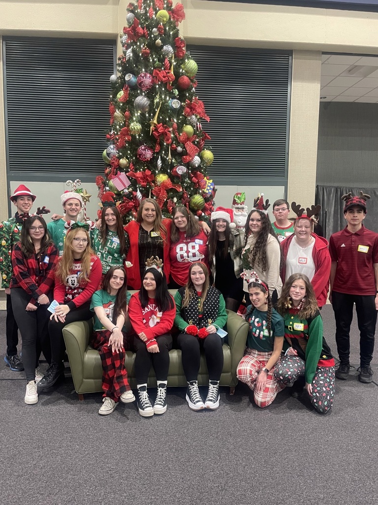 KAC members pose in front of a large Christmas tree 