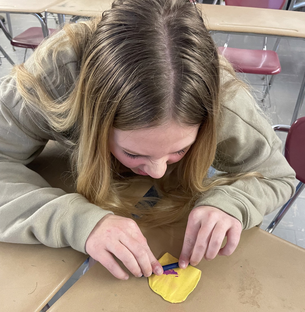 A student works on a cylinder seal at a desk 