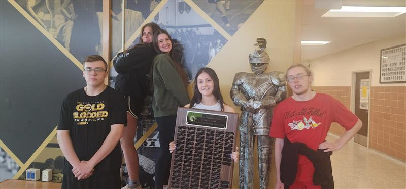 students posing with plaque