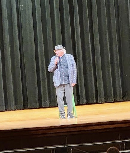 Gary farmer onstage wearing hat
