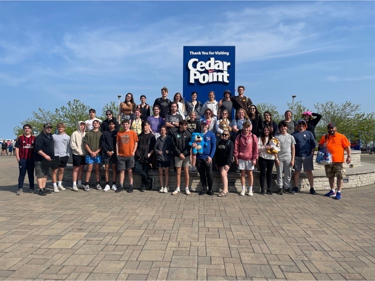 seniors pose in a group at a Cedar Point sign 